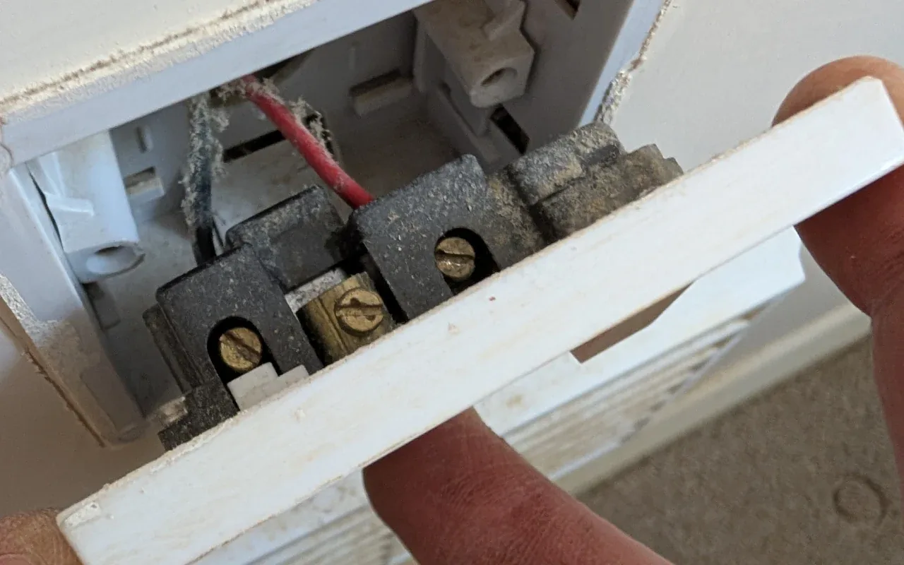 Old faceplate removed during electrical maintenance
