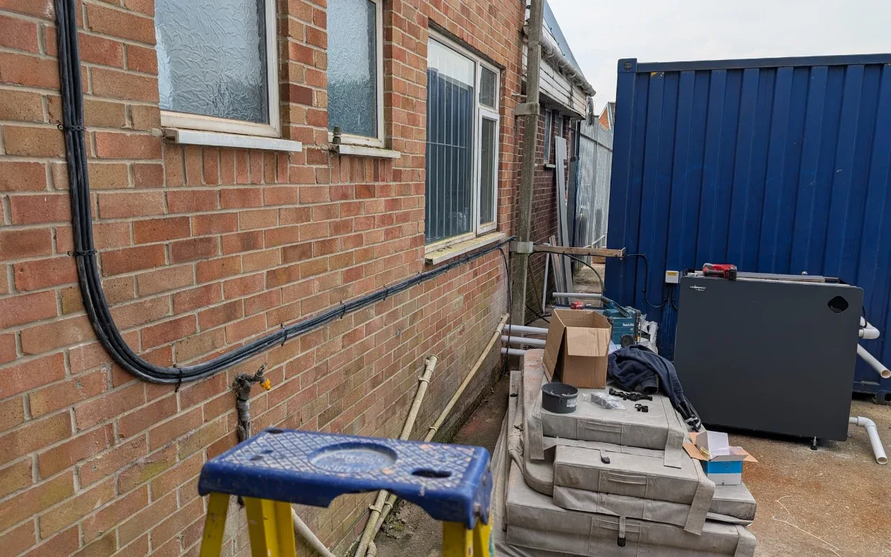 External cable run neatly clipped along a brick wall