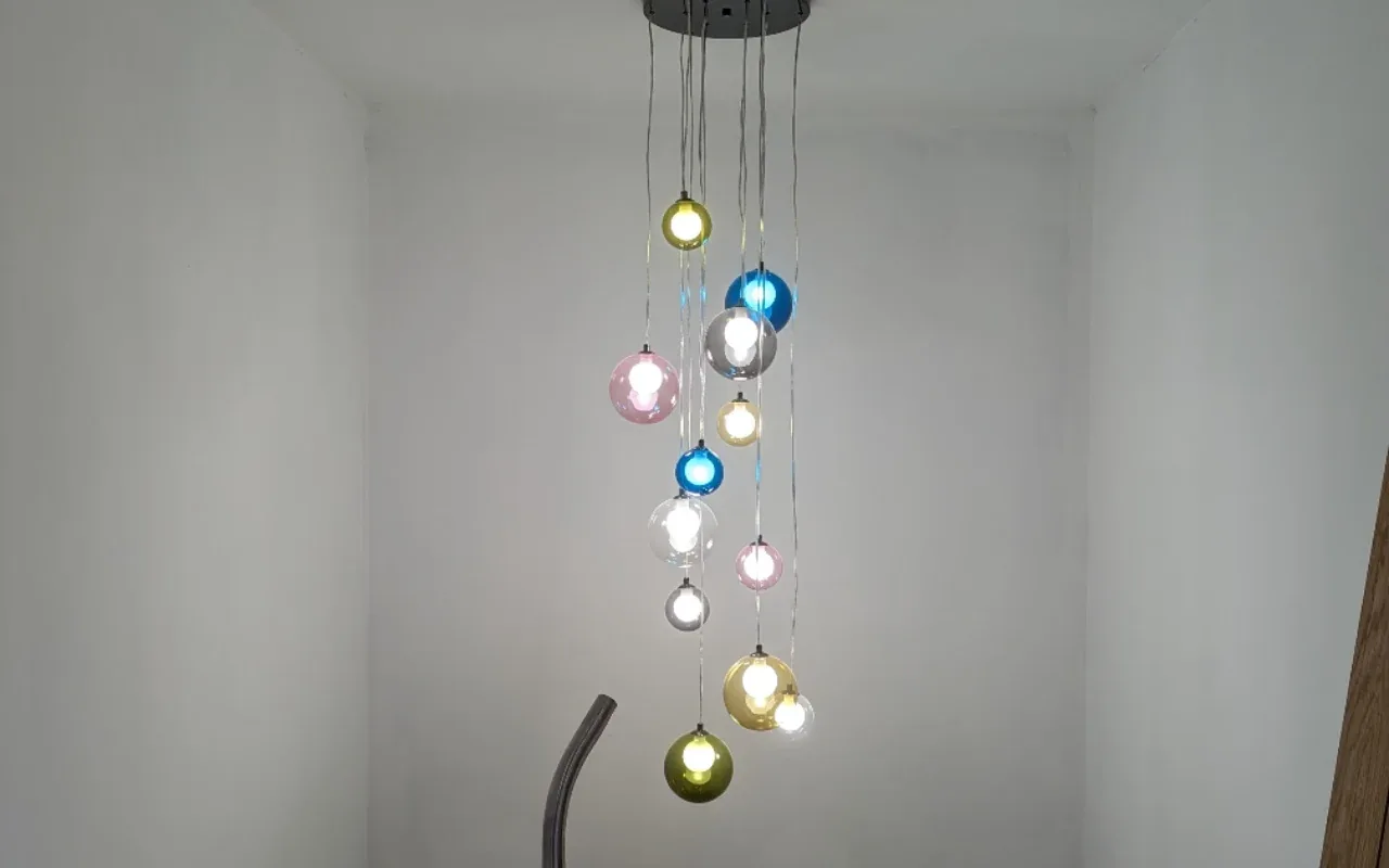 Multi-colour glass pendant light installed over a stairwell