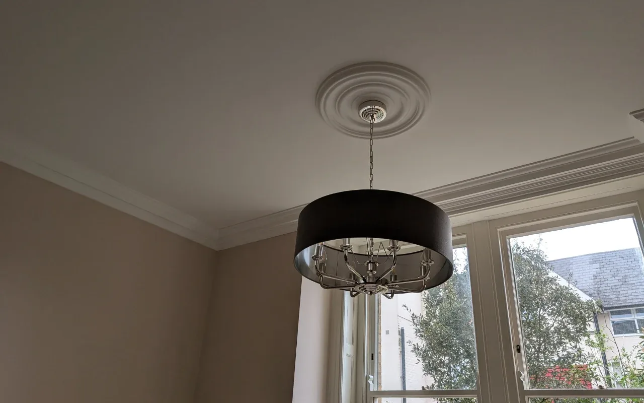 Black drum pendant light fitted to a ceiling rose
