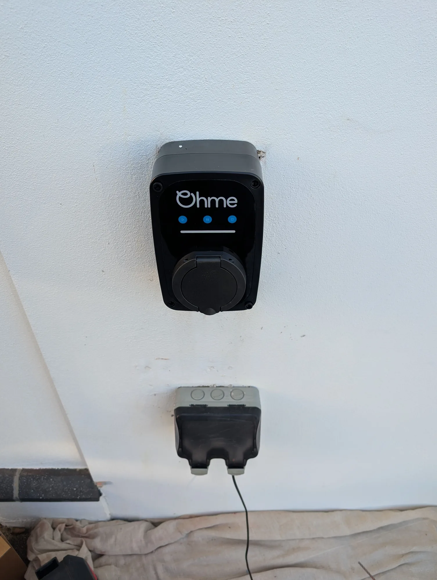 Ohme EV charger installed on an exterior wall