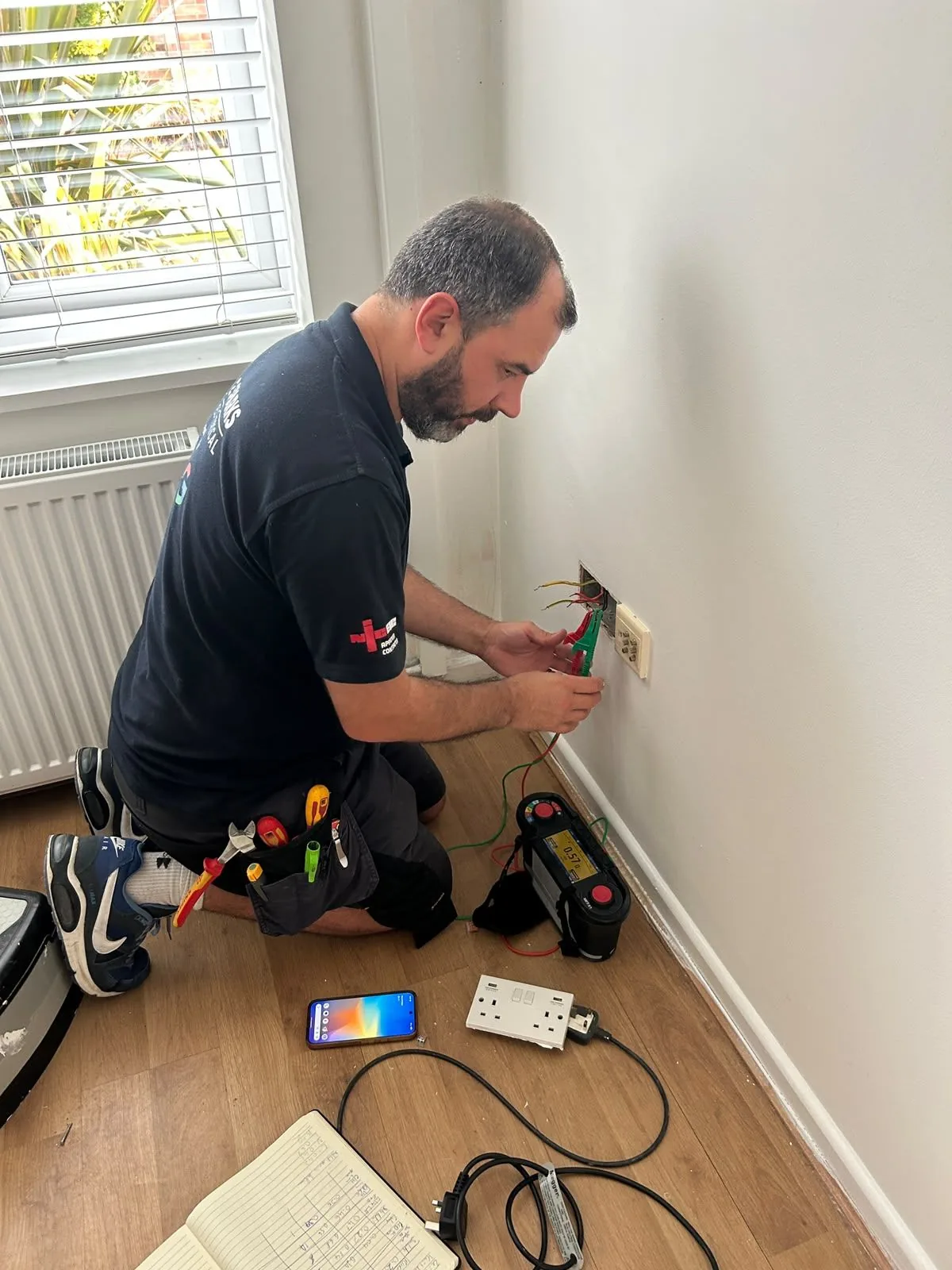 Jason Bridges of 2 Sparks Electrical testing an installation in Poole